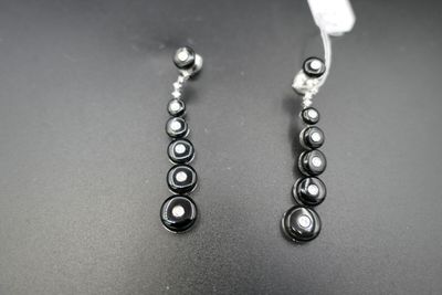 boucles d'oreilles en perles noires et blanches sur un fond noir
