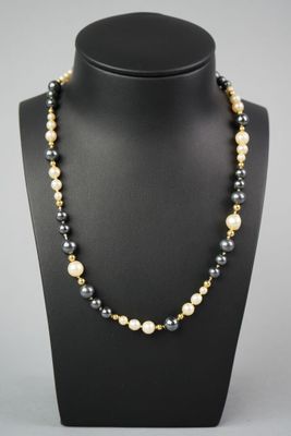 un collier de perles noires et blanches sur un mannequin