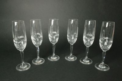 six verres à vin vides alignés sur un fond noir