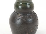 a brown vase sitting on a white surface with a white background