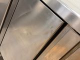 a stainless steel refrigerator in the middle of a kitchen