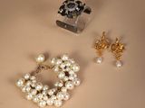 two pairs of earrings and a bracelet are sitting on a table