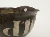 a brown bowl with white writing on it sitting on a table
