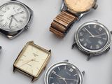 many different types of watches displayed on a table