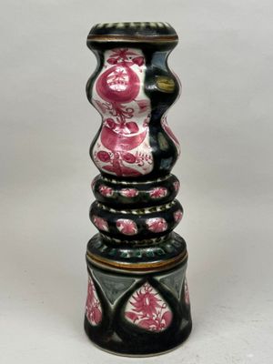 un vase noir et rose posé sur une table blanche