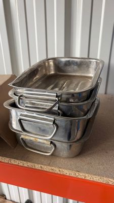 several metal pans are stacked on top of a red table
