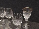 several empty wine glasses sitting on a table with a black background