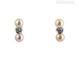 paire de boucles d'oreilles en perles et diamants sur fond blanc