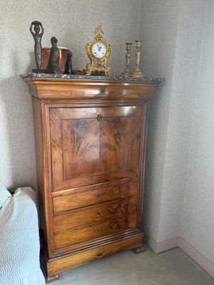 une commode surmontée d'une horloge, placée dans un coin de la pièce