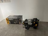 a black and yellow robot sitting on the floor next to a box