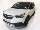 La voiture blanche est garée dans une pièce blanche au sol blanc.