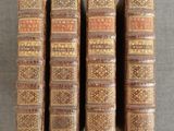 trois vieux livres posés sur une table l'un à côté de l'autre