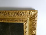 un miroir à cadre doré accroché au mur d'une pièce