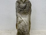 a stone statue of a man with a sword on a table