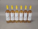 six bottles of wine are lined up in a row