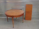 une petite table avec un plateau en bois, placée devant un mur métallique