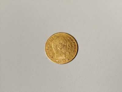 a close up of a gold coin on a white surface