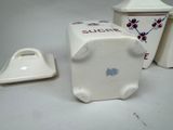 a white container with a red flower on it and a white container with a blue flower on it