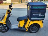 a yellow scooter with a box on the back of it
