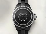 a close up of a black watch on a white surface