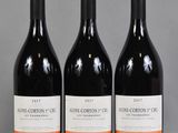 three bottles of wine are lined up on a table