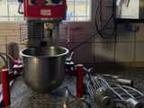 a red mixer and a whisk in a kitchen