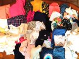 un saladier en bois rempli d'une multitude de vêtements, posé sur un sol carrelé
