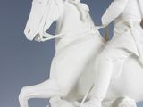 a statue of a man riding on a horse with a dog