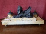 a statue of a sphinx sitting on a marble block