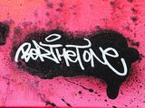 graffiti on a pink wall with a black and white writing on it