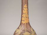 un vase marron orné d'une fleur jaune