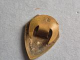 a close up of a small brass object on a white surface