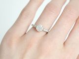 an image of a woman ' s hand with a diamond engagement ring