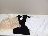 a white table topped with clothes and a black top