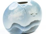 a blue vase with birds flying in the sky