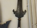 Plusieurs types d'armes sont exposés sur un mur blanc.