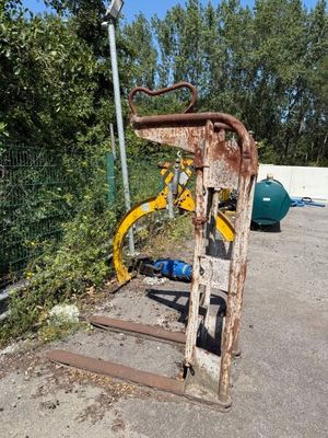 a rusted bike leaning against a fence in a parking lot