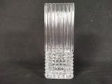 un vase en verre transparent posé sur une surface noire