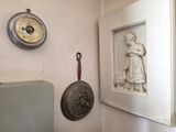 une photo d'un mur sur lequel sont accrochés une horloge et des casseroles