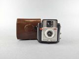 an old camera sitting next to a leather case