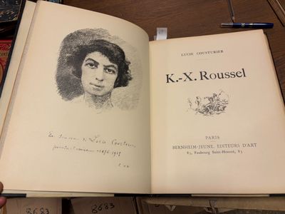 quelqu'un tient un livre sur lequel est dessiné le visage d'une femme