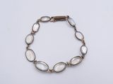 un bracelet en or orné de perles de verre blanches sur fond blanc