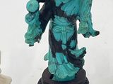 a statue of a woman holding a bird next to a statue of a man