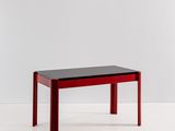 une image représentant une table rouge avec un plateau et des pieds noirs