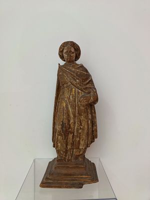 a statue of a man holding a book on a glass table