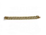 a gold bracelet with a curb on a white background