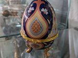 un œuf exposé dans une vitrine aux côtés de figurines