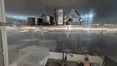 many pots and pans on the shelf in the kitchen