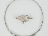a silver necklace with a blue stone in the center