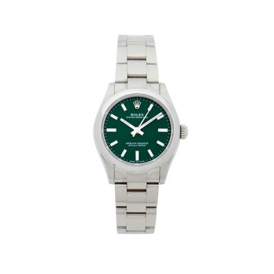 un gros plan d'une montre au cadran vert sur fond blanc